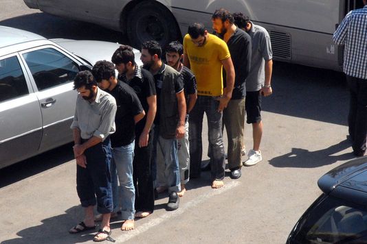 Des prisonniers arrivent au quartier général de la police à Damas en Syrie, en septembre 2012.