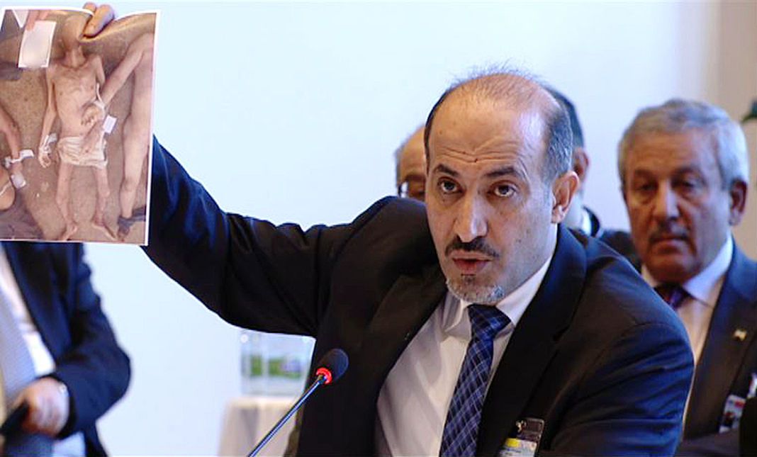 - / AFP Ahmed Jarba, chef de la Coalition nationale syrienne, brandit, le 22 janvier 2014 à Montreux, une des photographies de victimes du régime syrien prises par « César ».
