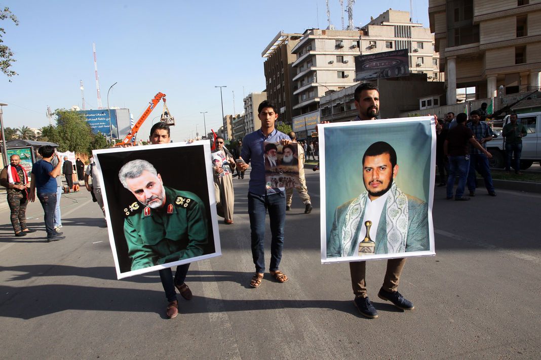 ALI AL-SAADI/AFP Le portrait du général Soleimani est brandi lors d’une manifestation, en mars 2015 à Bagdad, contre l’intervention militaire au Yémen de la coalition menée par l’Arabie saoudite. A droite, la photo du leader des rebelles houtistes, Abdel Malik Al-Houthi.