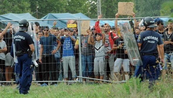 
Des réfugiés gardés par des policiers hongrois dans un camp proche de Roszke à la frontière serbe. photo AFP

AFP
