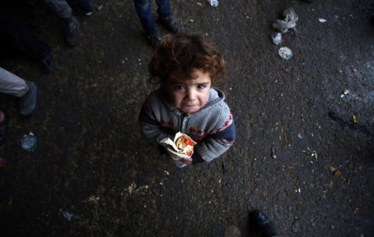 Un enfant syrien, qui a fui dans les zones d'Alep tenues pas les forces rebelle, vient de recevoir un sandwich, le 1er décembre 2016, dans un refuge dans le quartier de Jibrin, à l'est d'Alep. Photo Youssef Karwashan/AFP