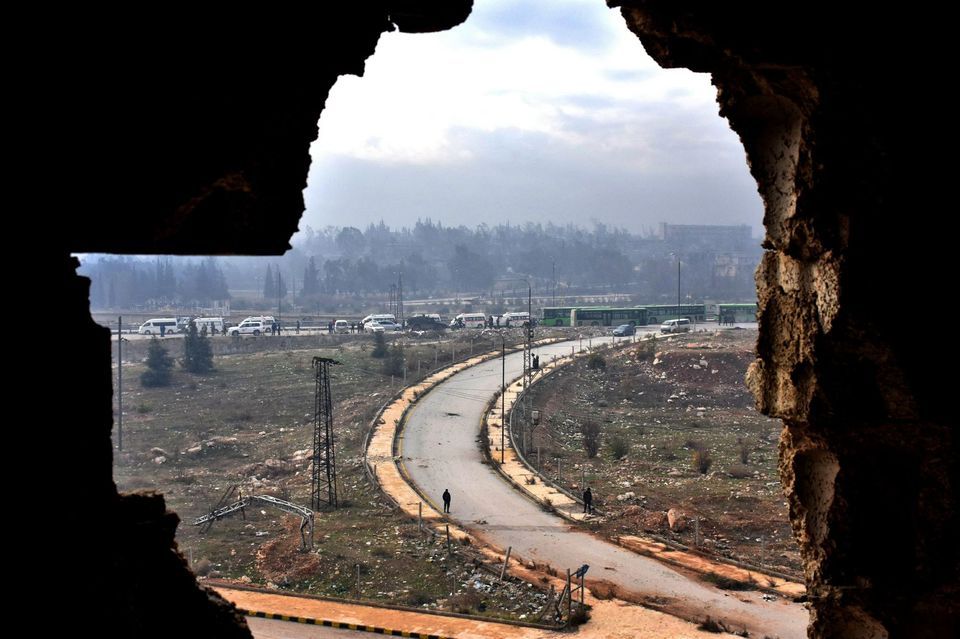 Des soldats du régime montent la garde devant les bus évacuant les habitants d’Alep, vendredi.