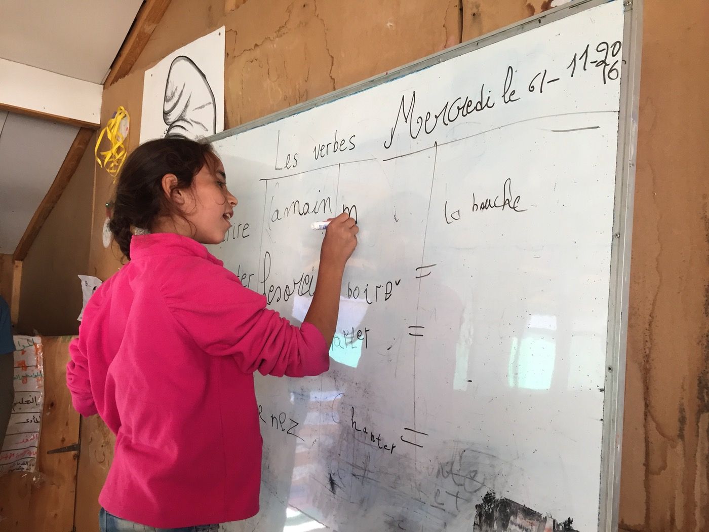 Ghoufran, nine years old, has flourished at school in Lebanon. She is quick to shout out a correct answer or volunteer to write out sentences on the board in carefully practiced cursive script. (Abby Sewell)