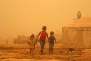 Syrian children walk amid a dust storm on September …