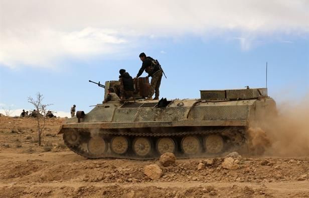 Fighters from the Syrian Democratic Forces (SDF) sit atop an armored personnel carrier on the outskirts of the town of Al-Shadadi in the northeastern Syrian province of Hasakeh, on February 19, 2016. (AFP/Delil Souleiman)